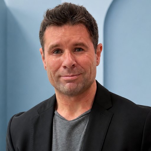 Will O&rsquo;Kane, photographed against a pale blue architectural backdrop.